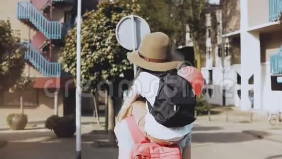 母亲把儿子扛在肩上女人带着一个戴帽子的孩子和两个气球走路生活方式4K视频的预览图