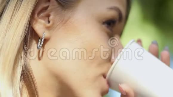 年轻女子喝着一次性杯子里的咖啡视频的预览图