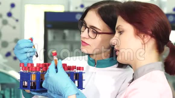 两位年轻的女性研究人员正在研究血液试管视频的预览图