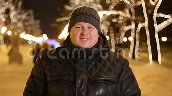 冬天寒冷的夜晚快乐的男人在户外微笑的肖像视频的预览图