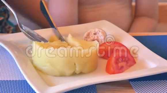 一个女人的勺子收集土豆泥和西红柿并喂养婴儿视频的预览图