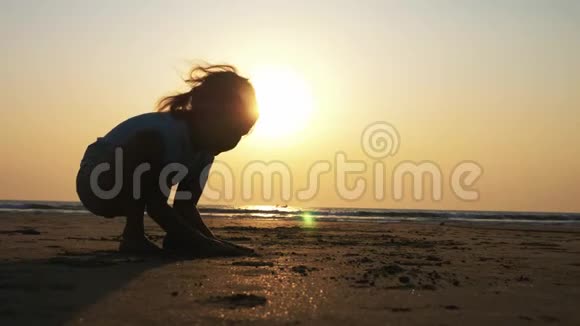 日落时分在海滩上做体操的小女孩剪影视频的预览图