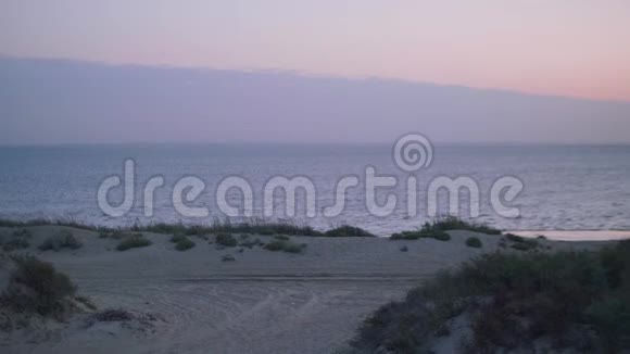 海景日出全景沙滩吐沙和沙滩帐篷景观视频的预览图