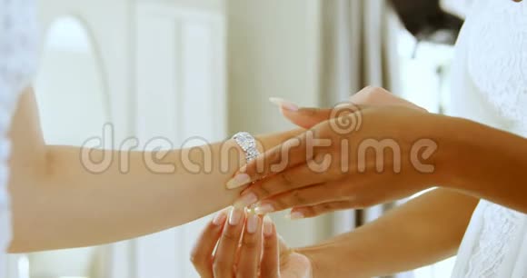 新娘戴着白色钻石手镯伴娘牵着她的手4K4k视频的预览图