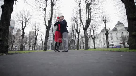 年轻可爱的男孩和女孩在裸树间的街头跳舞视频的预览图