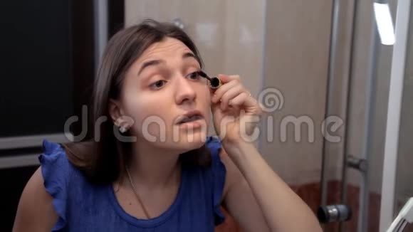 一个年轻女孩准备浪漫的晚餐化妆画眼睛睫毛膏视频的预览图
