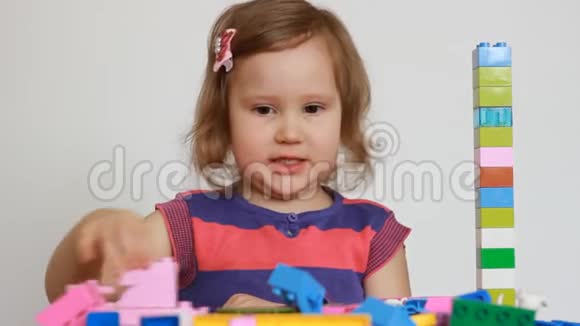小女孩玩五颜六色的小积木的一个建设者孩子培养自己的思维能力娱乐视频的预览图