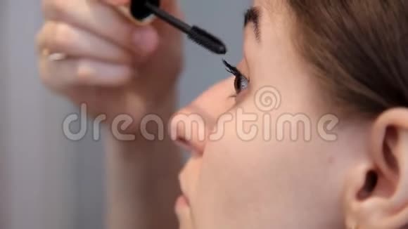 一个年轻女孩准备浪漫的晚餐化妆画眼睛睫毛膏视频的预览图