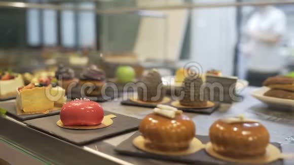 橱窗里陈列着各种各样的蛋糕糕点店有松饼巧克力水果蛋糕浆果视频的预览图
