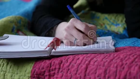 塞德年轻的女人躺在床上写日记青少年的经历慢动作视频的预览图