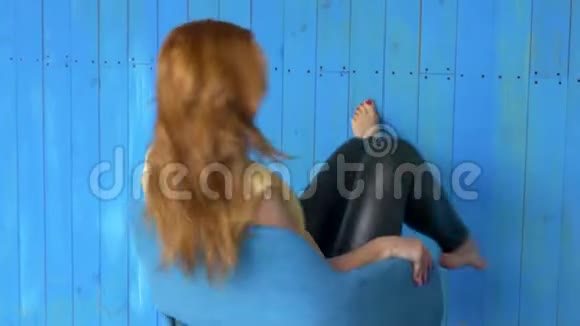照片中的年轻红发女士站在白色墙壁背景上孤立看着相机自拍视频的预览图