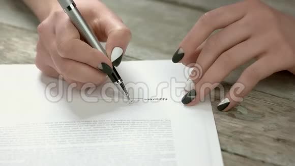 修剪整齐的手在文件上签字视频的预览图
