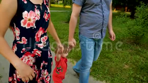 爸爸妈妈正牵着小幸福和微笑的宝宝手走来走去一家人在玩小孩走路视频的预览图