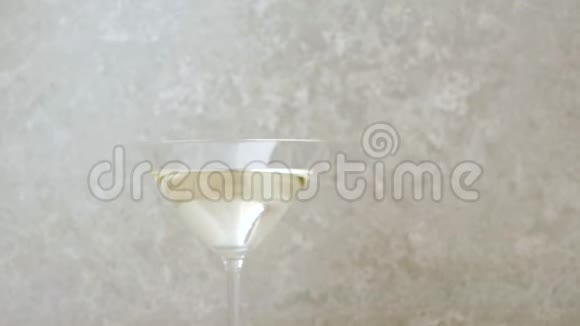 豪华马提尼手把一杯马提尼酒放在桌子上上面装饰着橄榄鸡尾酒棒酸橙和薄荷视频的预览图