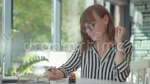 时髦的年轻女子从事书法墨水和笔视频的预览图