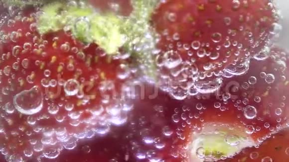 带有冰块和草莓的玻璃苏打水中间屏幕泡沫膨胀视频的预览图