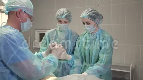 外科医生在手术室里教两个护士视频的预览图