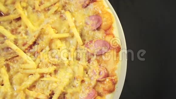 披萨的特写与奶酪和香肠围绕着自己从顶部的黑色背景视图视频的预览图