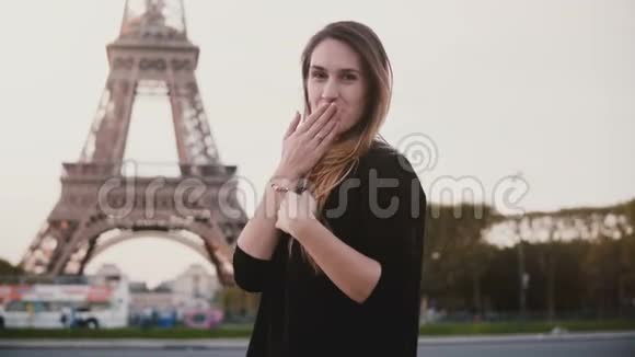 幸福美丽的女人站在法国巴黎埃菲尔铁塔附近女孩微笑着在镜头前发送吹吻视频的预览图