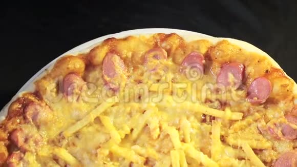 披萨的特写与奶酪和香肠围绕着自己从顶部的黑色背景视图视频的预览图