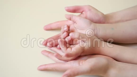 妈妈双手抚摸着孩子双手特写妈妈抱着孩子双手慢吞吞地走着视频的预览图
