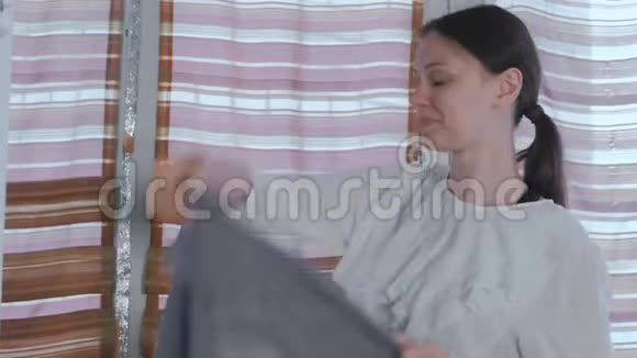 年轻漂亮的女人站在家里的镜子前头上戴着灰色的头巾视频的预览图