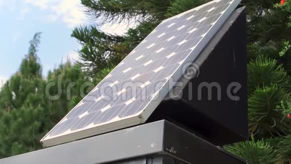 太阳能电池板覆盖着蓝色多云的天空和绿色的树木户外新的替代能源技术视频的预览图