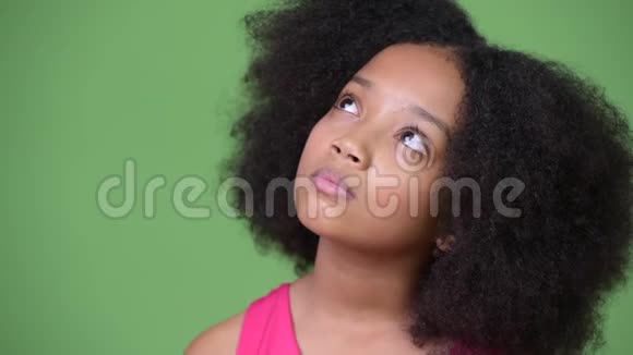 年轻可爱的非洲女孩一头非洲头发一边看一边思考视频的预览图