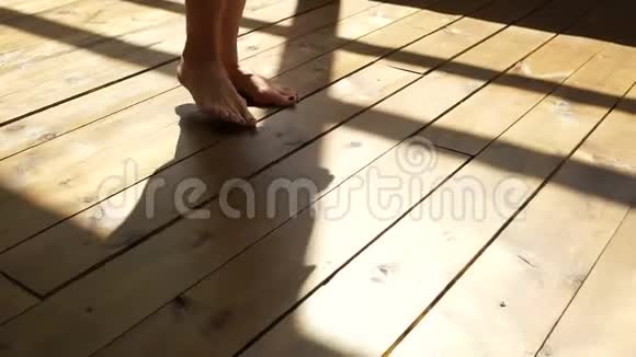 那个女孩正走在木地板上女性的脚在木地板上视频的预览图