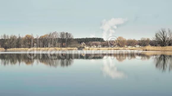 地平线上有巨大的烟雾云池塘湖边的芦苇阳光明媚的春天视频的预览图