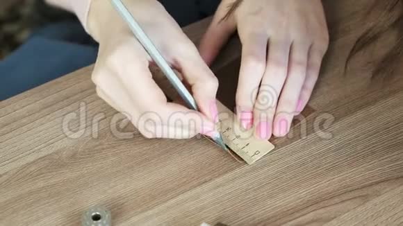 裁缝用铅笔和尺子测量皮革织物上的片段女人手特写视频的预览图