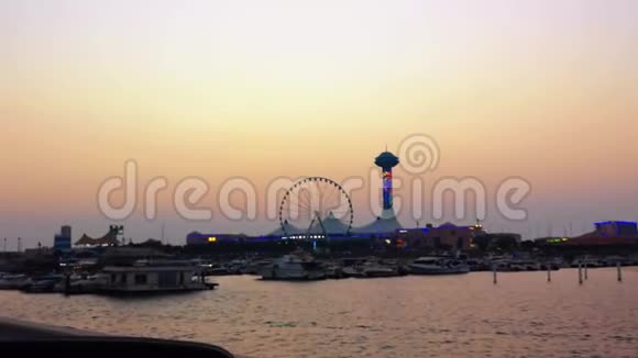 日落时美丽的滨海购物中心和滨海眼轮景观阿布扎比海滩和船只视频的预览图
