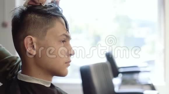 理发师用剪刀剪她的头发年轻人的头发剪了视频的预览图