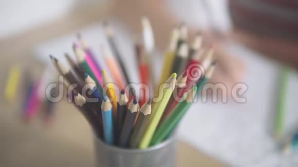 桌上一堆彩色铅笔相机幻灯片一个女人的手拿着一支铅笔在一个视频的预览图
