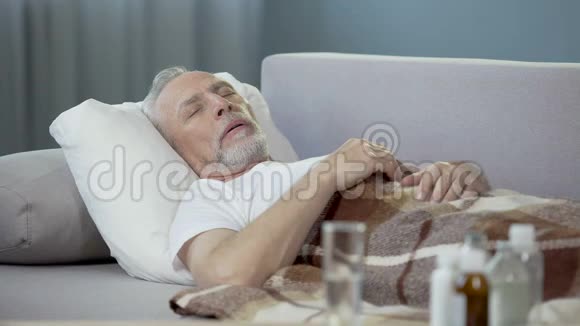 老年男性睡在沙发上患有高温疾病视频的预览图