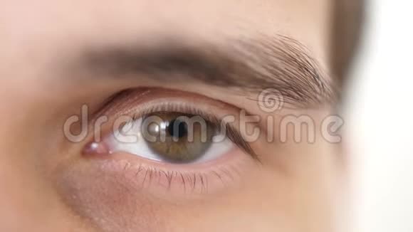 闭上一只雄性的眼睛打开一只棕色眼睛的男人看相机的细节慢动作3840x2160视频的预览图