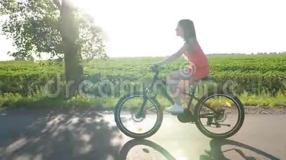 夏天少女骑着自行车穿过田野视频的预览图
