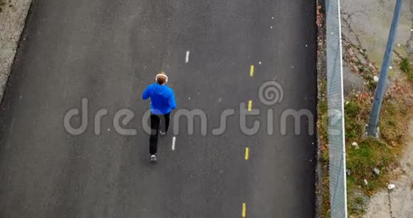 男子在街上慢跑时听音乐4K视频的预览图
