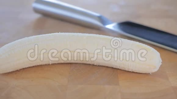 一根香蕉和一把刀在切割板上特写视频的预览图