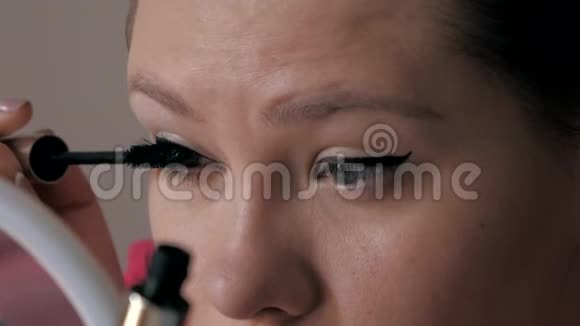 美丽的白种人女孩用大刷子染睫毛时尚界化妆品视频的预览图