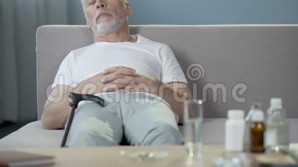 我孤独的祖父睡在沙发上药物站在桌子上视频的预览图