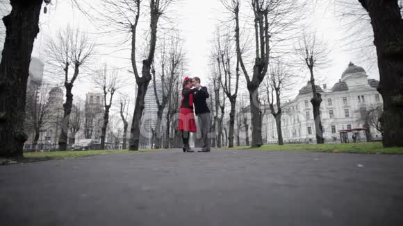 男人和女人在灰色的冬天公园裸树间有感情地跳探戈视频的预览图