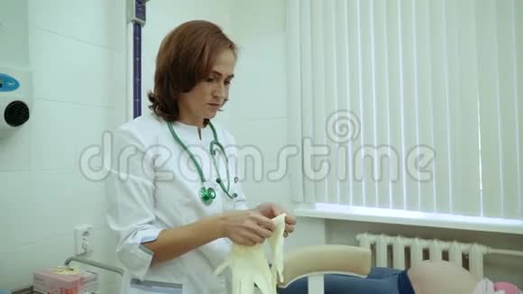 女人在检查怀孕女孩之前医生戴上手套孕妇躺在沙发上一个妇科医生视频的预览图