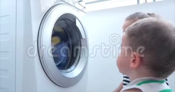 可爱的孩子们在洗衣机里看气缸旋转机概念洗衣机工业视频的预览图