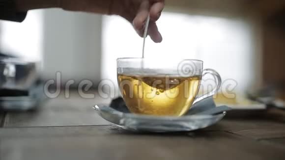 女人在机场的一家咖啡馆里手在一杯茶里搅动糖视频的预览图