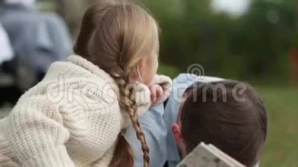 小女孩坐着拥抱她的父亲读一本书视频的预览图