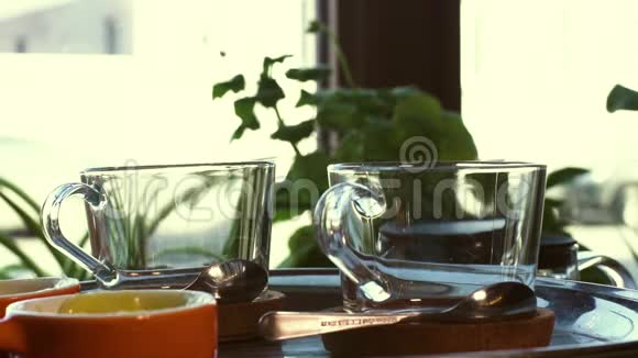 两个玻璃杯和茶匙站在托盘上视频的预览图