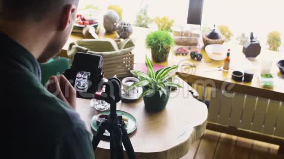 用数码相机拍摄人体三脚架并在木桌上制作食物照片视频的预览图