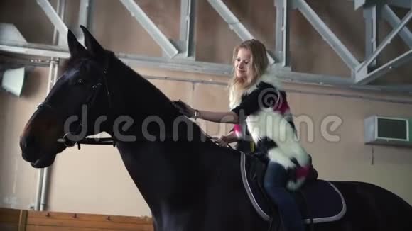动物骑马概念年轻女子坐在马背上抚摸着它的边缘视频的预览图