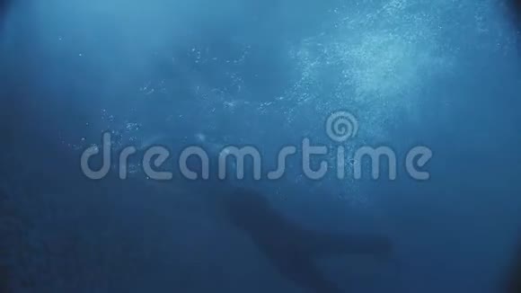 游泳男子在水下的一个黑暗的游泳池惊人的灯光掉进水里视频的预览图